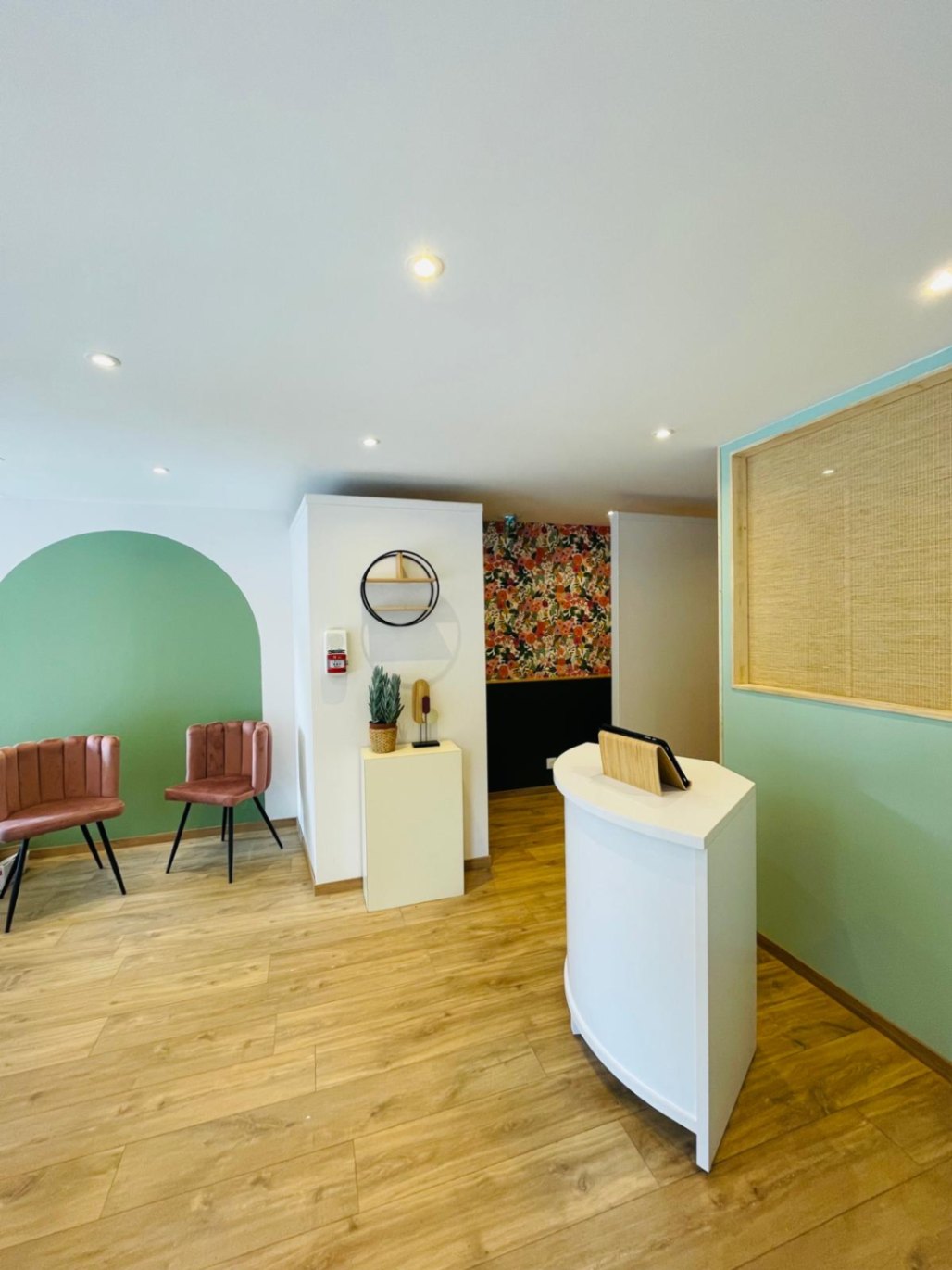 mise en beauté pour cet institut avec un parquet bois clair un soubassement vert et un papier peint à fleur